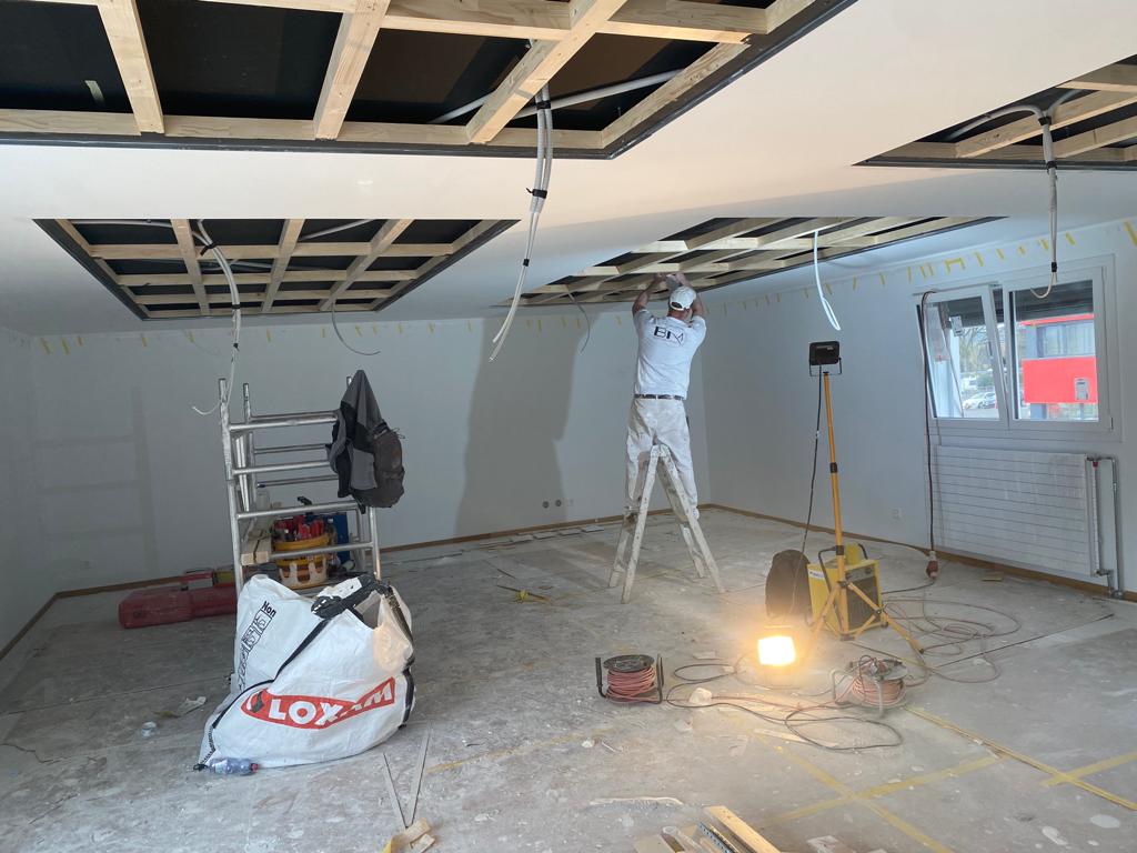 Gipser in einem Raum auf der Leiter der renoviert wird.